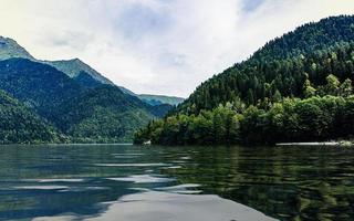 paisagem com lago ritsa e montanhas com céu azul nublado foto