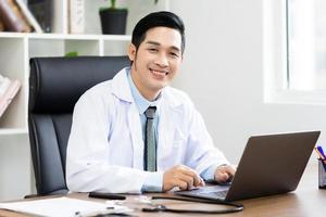 ásia masculino médico retrato sentado às trabalhos foto