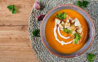 abóbora sopa dentro uma tigela servido com salsinha e croutons. vegano sopa. Ação de graças dia Comida. dia das Bruxas refeição. topo Visão foto