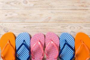 muitas sandálias coloridas flip flop, férias de verão em fundo de madeira, copie a vista superior do espaço foto