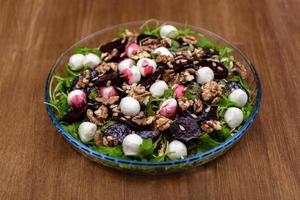 salada de rúcula na mesa de madeira foto