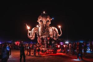 pessoas caminhando para pôr do sol às uma festival dentro a deserto às a queimando homem festival. foto