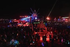 pessoas caminhando para pôr do sol às uma festival dentro a deserto às a queimando homem festival. foto