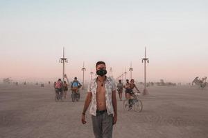 pessoas caminhando para pôr do sol às uma festival dentro a deserto às a queimando homem festival. foto