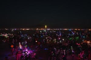 pessoas caminhando para pôr do sol às uma festival dentro a deserto às a queimando homem festival. foto