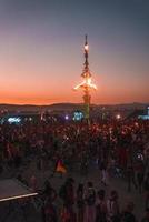 pessoas caminhando para pôr do sol às uma festival dentro a deserto às a queimando homem festival. foto