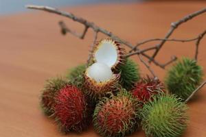 rambutan fruta que é avermelhado verde dentro cor tendo doce gosto isolado em mesa. Comida conceito foto. foto