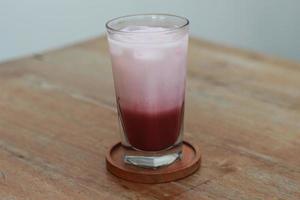 uma vidro do vermelho veludo café com leite servido frio em a mesa. foto