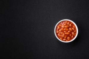 delicioso enlatado feijões dentro uma tomate dentro uma branco cerâmico tigela foto