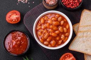 delicioso enlatado feijões dentro uma tomate dentro uma branco cerâmico tigela foto