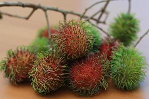 rambutan fruta que é avermelhado verde dentro cor tendo doce gosto isolado em mesa. Comida conceito foto. foto