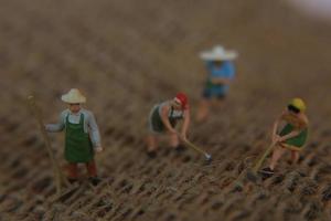 miniatura figuras do agricultores trabalhando em gunny sacos. conceito do agricultura foto. foto