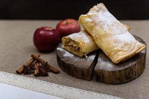 strudel de maçã na extremidade de madeira de uma árvore com maçãs, canela e anis estrelado foto