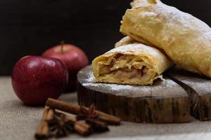 strudel de maçã na extremidade de madeira de uma árvore com maçãs, canela e anis estrelado foto