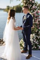 cerimônia de casamento em um píer alto perto do rio foto