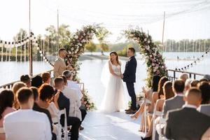 cerimônia de casamento em um píer alto perto do rio foto