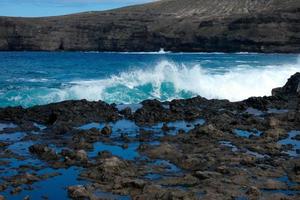 ampla ondas falhando contra a pedras dentro a oceano foto