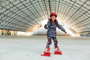 pequeno menina patins em rolo rinque foto