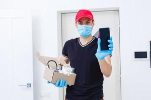 Entrega homem segurando cartão caixas dentro borracha luvas e médico mascarar. cópia de espaço. velozes e livre Entrega transporte . conectados compras e expressar Entrega foto