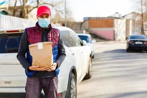 correio dentro protetora mascarar e médico luvas entrega Leve embora Comida. Entrega serviço debaixo quarentena, doença surto, coronavírus covid-19 pandemia condições. foto