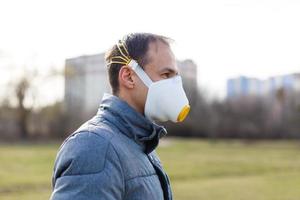 ásia homem vestindo a face mascarar vencimento para ar poluição - jovem adulto em parque com poluição mascarar - pessoa protegendo a partir de ar contaminação ou coronavírus ou covid-19 de vestindo mascarar. foto