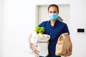 conceito de entrega, correio e pessoas - homem feliz entregando comida em saco de papel descartável para casa do cliente foto