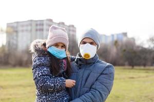 pai é vestindo uma mascarar para dele pequeno filha para proteger a criança a partir de PM 2,5 ar poluição e COVID-19, conceito do pessoas estilo de vida dentro crise do doença surto e ar problema. foto