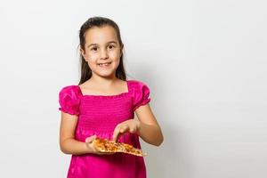 fofa pequeno indiano ásia menina criança comendo saboroso pizza. em pé isolado sobre branco fundo. foto