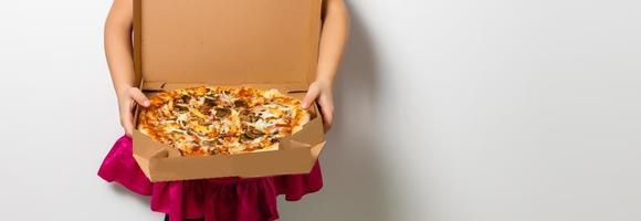 feliz pequeno menina com pizza dentro uma papel caixa foto