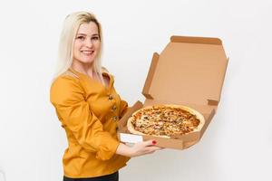 bonita jovem casual mulher com saboroso pizza dentro Entrega papel caixa. isolado em branco fundo foto