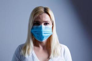 a atraente jovem mulher desgasta uma papel face mascarar para proteger ela mesma a partir de a h1n1 vírus, isolado, com quarto para seu texto foto