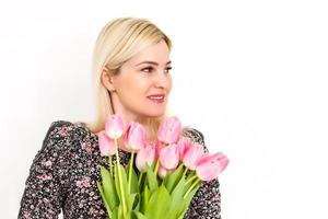 retrato do uma lindo jovem menina dentro vestir segurando grande ramalhete do tulipas sobre branco fundo foto