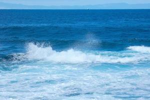 ampla ondas falhando contra a pedras dentro a oceano foto