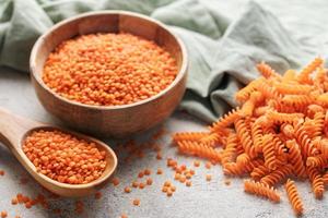 fusilli vermelho lentilha massa em uma cinzento concreto fundo. foto