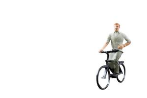 figura em miniatura andando de bicicleta isolada em um fundo branco foto