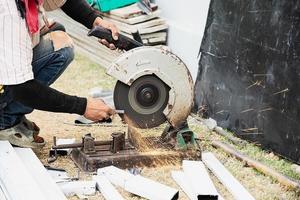 construção homem trabalhando com aço corte e esmerilhamento máquina, pessoas trabalhando às construção local conceito foto