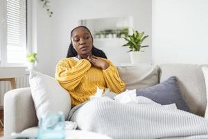 doente dia às lar. jovem mulher tem dolorido garganta e comum frio. tosse. fechar-se do lindo jovem mulher apanhado frio ou gripe doença. retrato do pouco saudável menina com coronavírus, covid19 sintomas foto