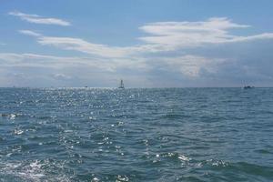 paisagem marinha com barcos distantes em um corpo de água contra o céu azul nublado em sochi, rússia foto