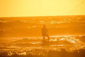 kitesurfer às pôr do sol foto