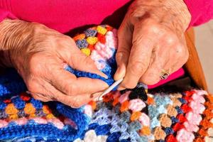velho mulher com tricô agulhas e lã foto