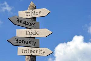 ética, respeito, código, honestidade, integridade - de madeira placa de sinalização com cinco Setas; flechas, céu com nuvens foto