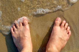 pés degrau em a de praia foto