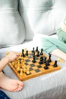 dois crianças estão jogando xadrez fechar-se. faz uma cavaleiro e penhor mover foto