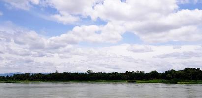 lindo azul céu com branco nuvens, rio e verde árvore para fundo. beleza do natureza e natural papel de parede concep foto