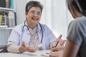 envelhecido ásia médico psiquiatra, geral mulher médico consultando preocupado com Adolescência menina paciente, adulto explicando diagnóstico, compromisso às clínica, hospital. saúde Cuidado, Verifica acima médico. foto