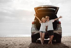 carro estrada viagem viagem do casal desfrutando de praia relaxante em de capuz do Esportes Utilitário carro. feliz ásia mulher, homem amigos sorridente juntos em período de férias final de semana feriados em a de praia. foto