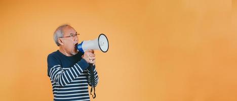 Senior masculino gritando com megafone para anunciar notícia ou desconto venda compras em cor fundo. foto