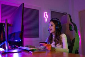 topo acima conectados jogos com crédito cartão conceito. jogador e e-sport conectados do ásia mulher jogando conectados computador vídeo jogos com iluminação efeito, transmissão transmissão viver às lar. jogador e e-sport jogos foto