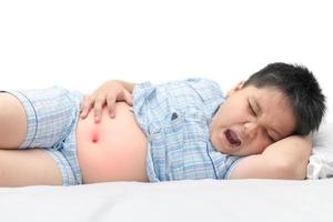 gordo criança sofrimento a partir de dor de estômago isolado foto