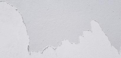 branco pintado rachado em cinzento cimento parede para fundo com cópia de espaço. mau pintura, estragado e velho grunge papel de parede. foto